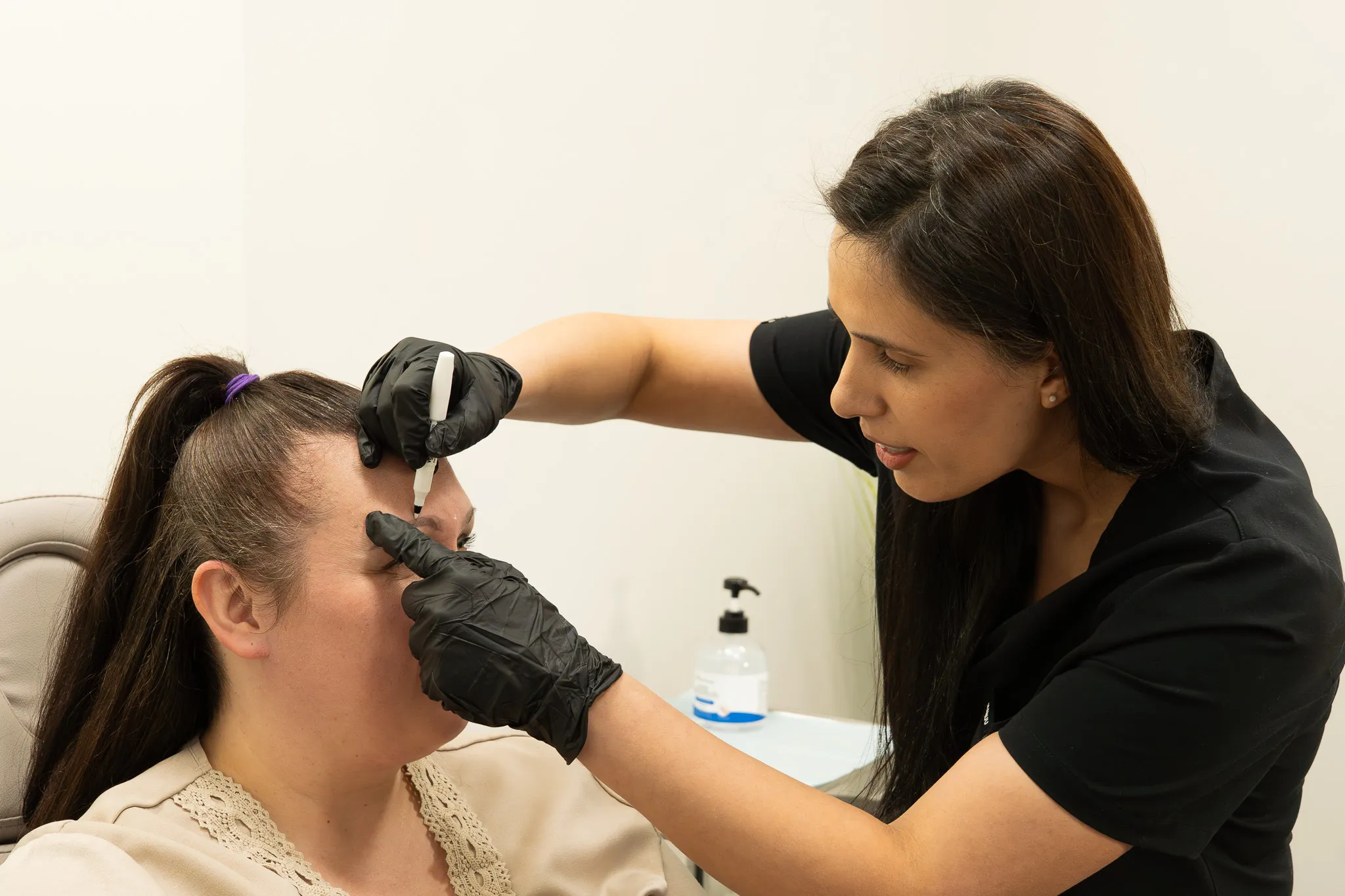 Dr. Sarai marks treatment points on a patient’s brow before a procedure.